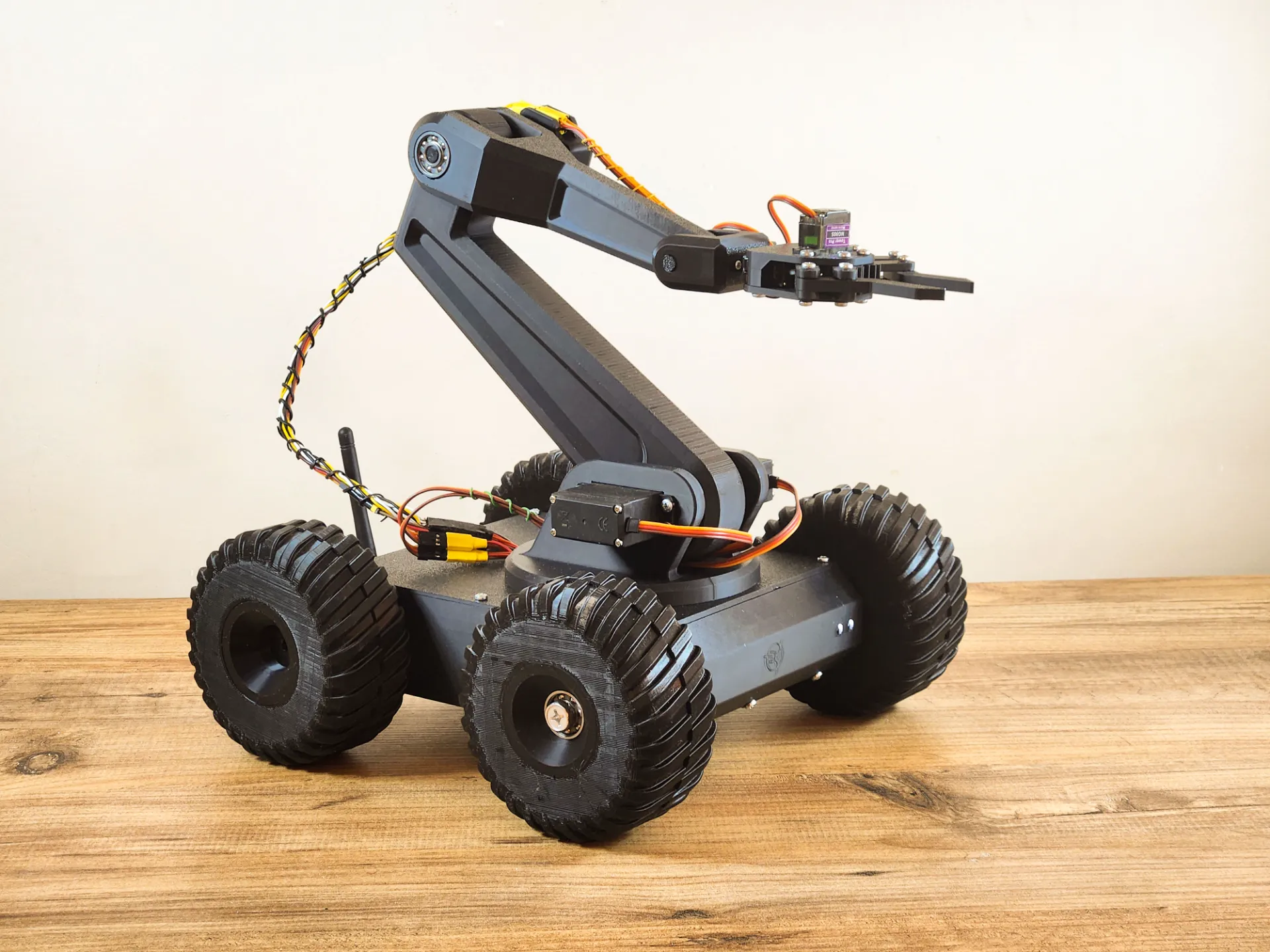 3D-printed four-wheeled rover fitted with a six-axis robotic arm and gripper